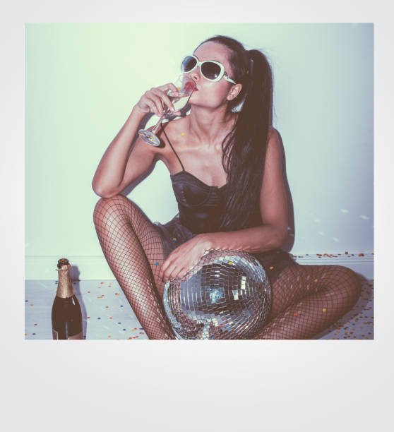 Direct flash of an asian woman drinking champagne sitting on ground